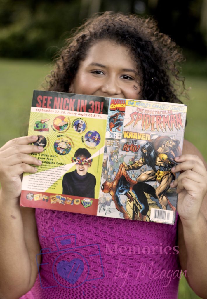 Girl with spider man comic book at a senior photoshoot. 