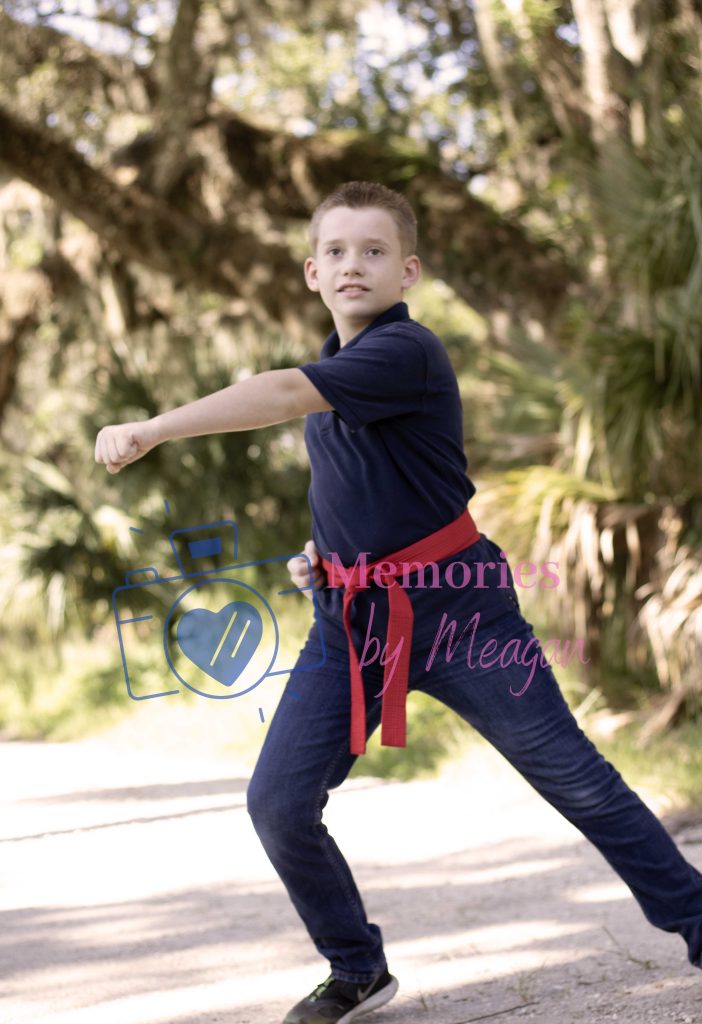 Child doing karate moves at a Florida nature reserve. 