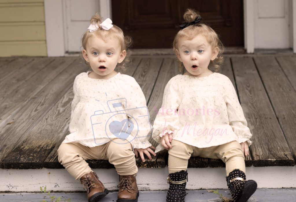 Twins sitting on a porch together. 